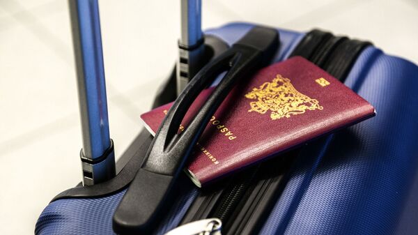 Un pasaporte y una maleta (imagen referencial) - Sputnik Mundo