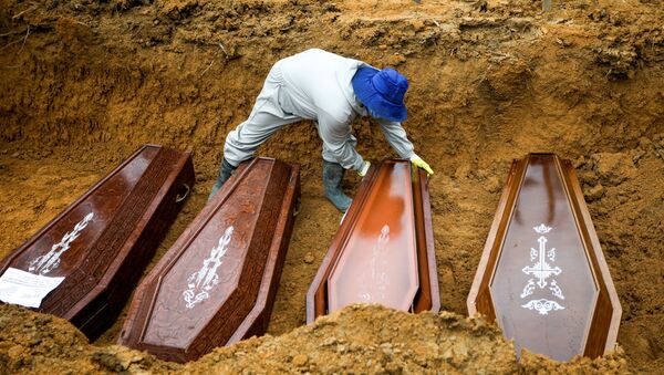 Un sepulturero trabaja durante un entierro masivo de personas que fallecieron debido al COVID-19 en Brasil - Sputnik Mundo