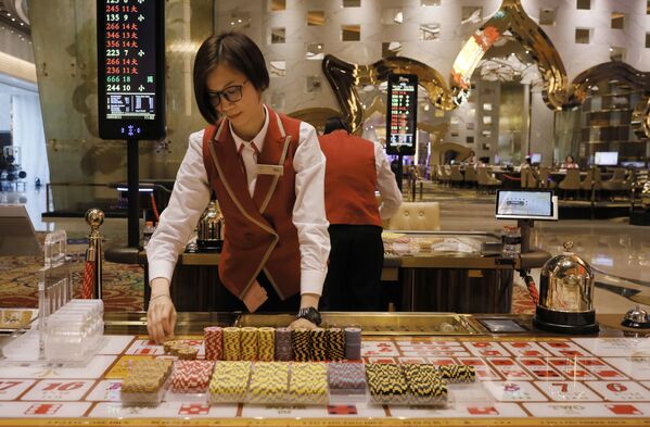 A croupier works at a gaming table at MGM Cotai Resort in Macau - Sputnik Mundo
