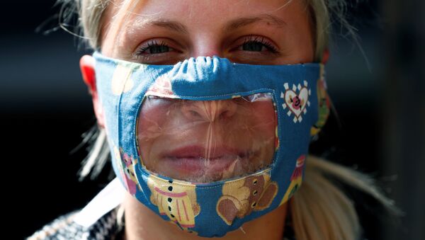 Una mujer con mascarilla transparente - Sputnik Mundo