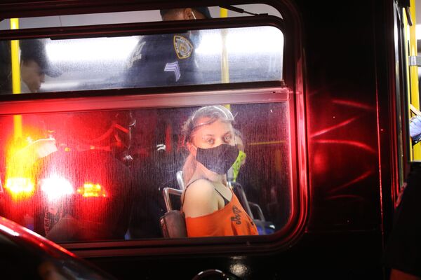 Протестующая в маске после задержания в полицейском автобусе у Барклайс-Центр в Бруклине, США - Sputnik Mundo