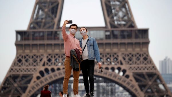 Una pareja con mascarillas cerca de la Torre Eiffel - Sputnik Mundo