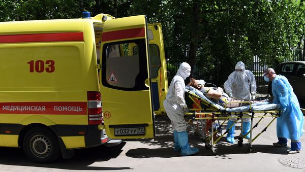 El personal de una ambulancia traslada a un paciente sospechoso con coronavirus en Moscú - Sputnik Mundo