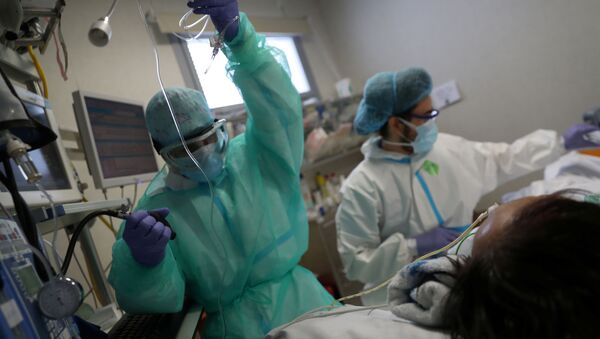 Personal médico atiende a un paciente con COVID-19 en España - Sputnik Mundo