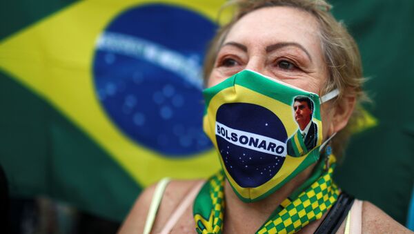 Una mujer brasileña con una mascarilla con la imagen de Bolsonaro - Sputnik Mundo