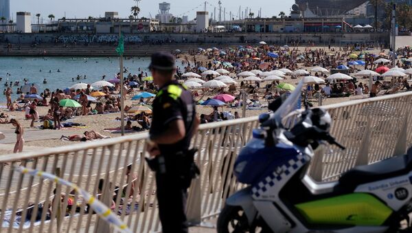 Un oficial de policía observa cómo la gente disfruta en la playa - Sputnik Mundo