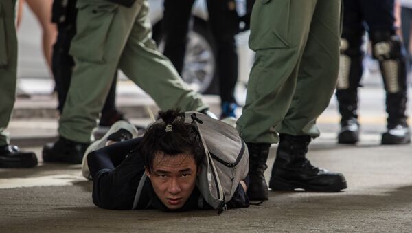 Задержанный полицией участник акции протеста против нового закона о национальной безопасности в Гонконге - Sputnik Mundo