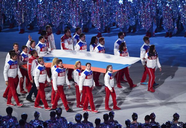 La entrada solemne de la bandera nacional de Rusia en la ceremonia de clausura de los XXII Juegos de Invierno en Sochi. - Sputnik Mundo