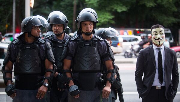 Полиция и участник марша миллионов масок в Бразилии - Sputnik Mundo